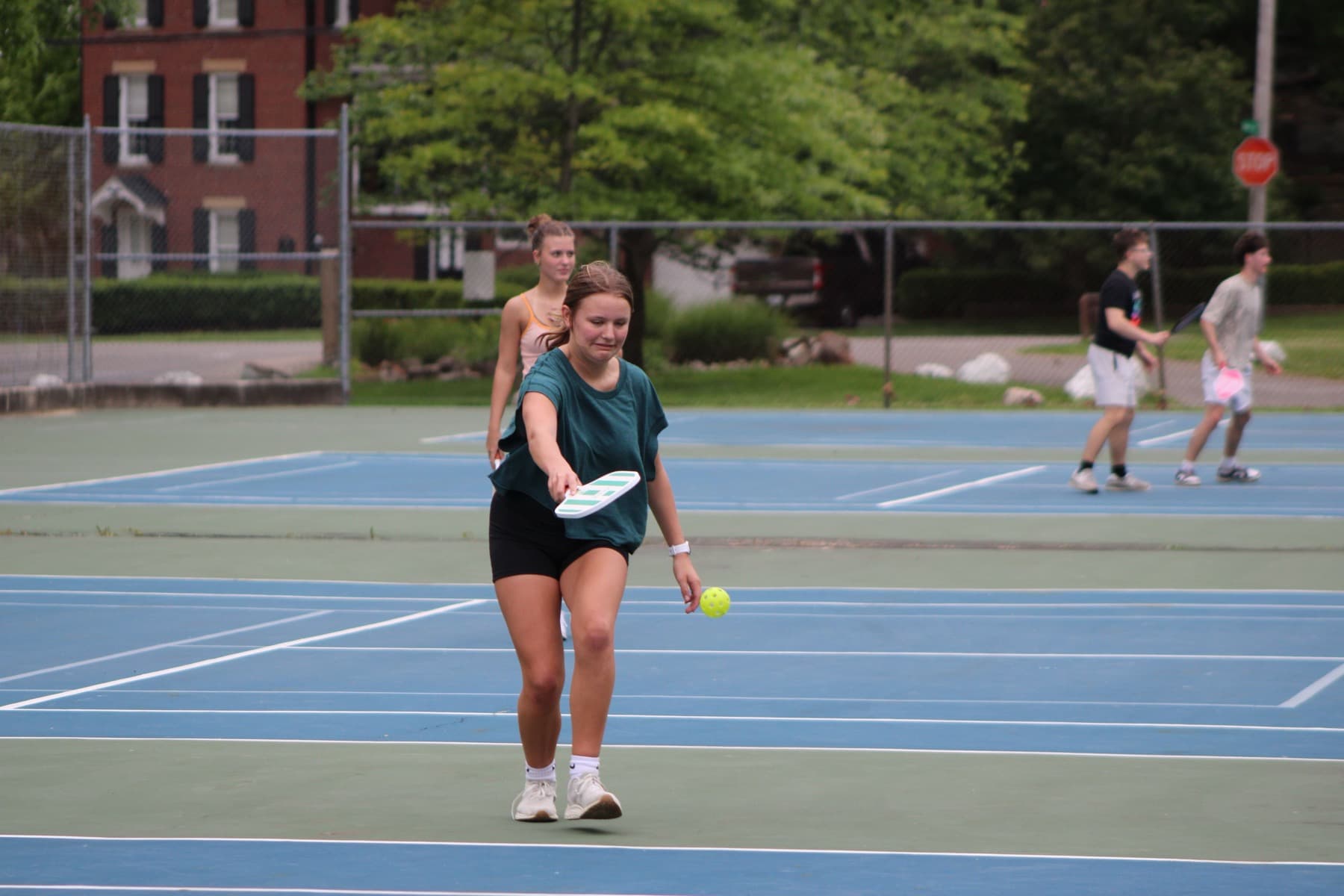 Jugadora sacando en un partido de pickleball